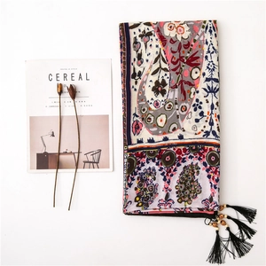Detail view of ethnic paisley cotton linen shawl with wood bead tassels and floral patterns