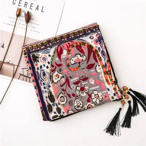 Ethnic embroidered clutch with floral patterns, long tassels, and carved wooden beads