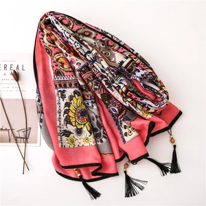 Detail of bohemian floral cotton linen scarf with black tassels and decorative wood beads