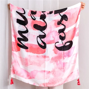 Detail of pink watercolor cotton linen scarf with cursive lettering and tassel edge