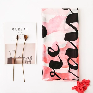 Pink and white gradient linen scarf with black letters and red tassels on white background