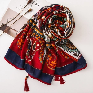 Detail of bohemian paisley shawl showing handcrafted wooden beads and red tassels