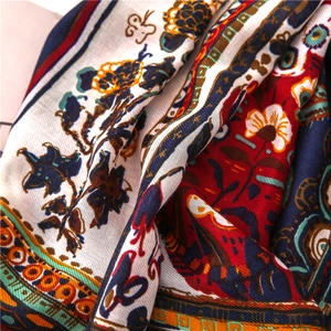 Detailed close-up of retro floral and butterfly patterns on a linen blend scarf
