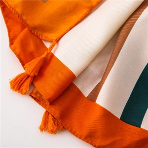 Detail of orange and white striped cotton linen scarf with fine tassel fringe and soft texture