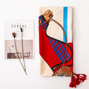 Detailed view of equestrian horse print scarf with red tassels and minimalist decor