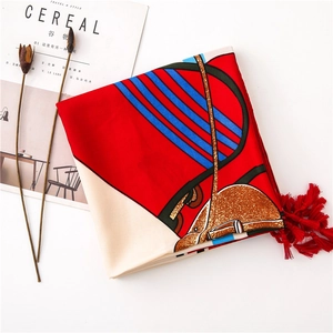 Close-up of a vintage horse harness print scarf with vibrant red fringe and silk texture