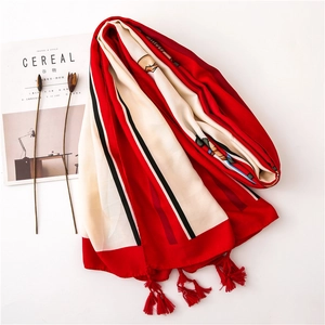 Detailed view of red cotton linen shawl with modern stripes and tassel edges