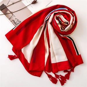 Macro view of red, white and black linen scarf with handmade knotted fringe tassels