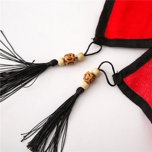 Detail of red floral scarf featuring black tassels and vintage wooden bead accents