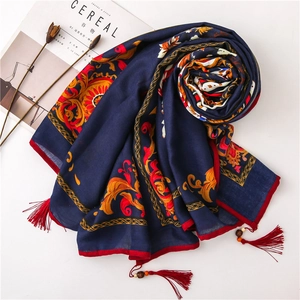 Macro view of floral pattern and handmade wooden bead tassels on linen scarf