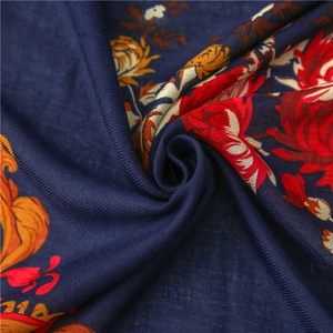 Detail of navy cotton linen scarf showing red floral print and handmade wood bead tassels