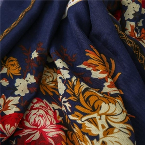 Close-up of blue cotton linen scarf featuring red peony print and wood bead tassels