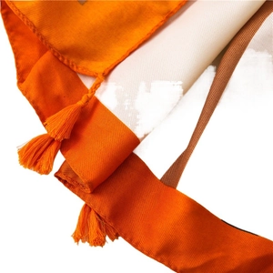 Orange linen scarf with textured twill weave and handcrafted tassel edges for beach travel
