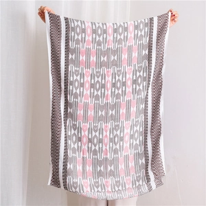 Detailed pattern of a long geometric print scarf with soft fringe edges and light texture