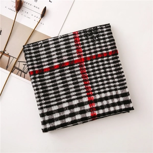 Detail of classic black and white plaid scarf fabric with red stripe accents and texture