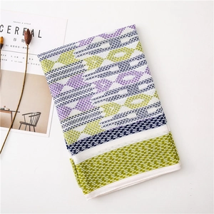 Close-up of cotton linen scarf featuring geometric patterns and soft tassel details