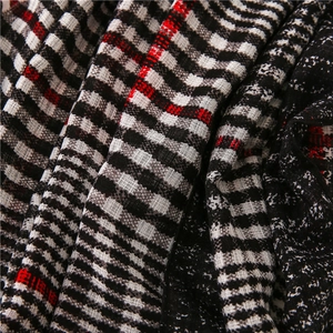 Detailed view of woven black, white, and red classic plaid scarf fabric texture