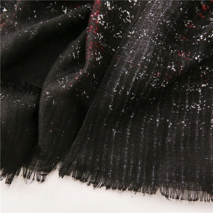 Detail of black gradient scarf with red speckles and natural fringe edges