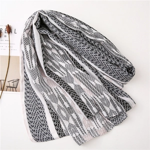Detail of soft black and white H-pattern scarf with stylish tassels and geometric design