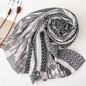 Close-up of cotton-linen scarf with H-letter patterns and pink geometric borders