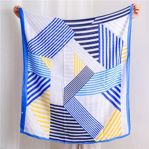 Detail of blue and white geometric stripe scarf showing premium stitching and fabric texture