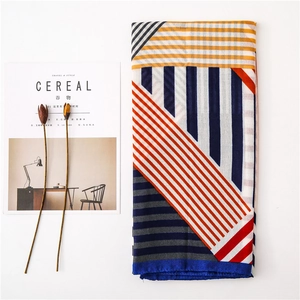 Detailed view of folded scarf with colorful geometric patterns and silk-like texture
