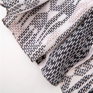 Detail shot of lightweight cotton-linen scarf fabric with brown geometric pattern