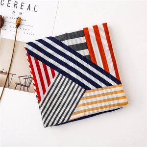 Detail of red and blue geometric scarf with mixed patterns on a minimalist background
