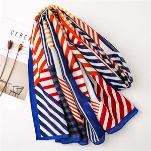Detail shot of geometric red and blue patterned long scarf on a white background