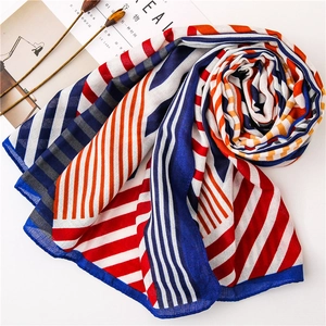 Detail shot of a long scarf with red and blue geometric stripes on white background