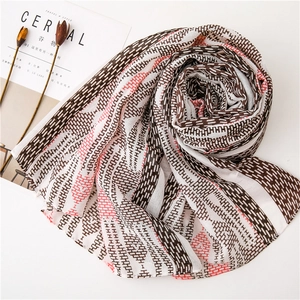 Close-up of geometric patterned scarf with fringe details and soft cotton-linen feel