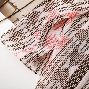 Detail shot of the cotton-linen feel scarf with classic geometric H pattern and fringe