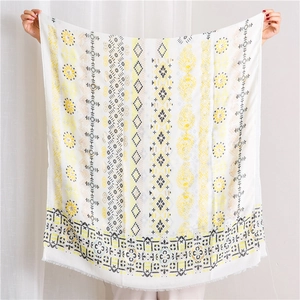 Close-up of bohemian linen shawl featuring gold-stamped paisley and tassel fringe