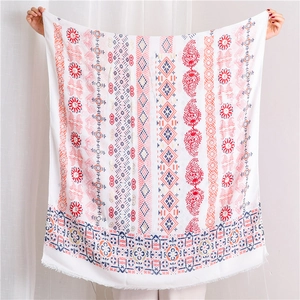 Close-up of bohemian linen scarf with colorful paisley patterns and fringe details