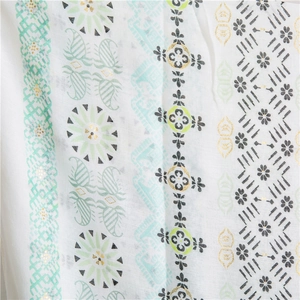 Detail of white cotton linen scarf with mint paisley print and gold foil accents