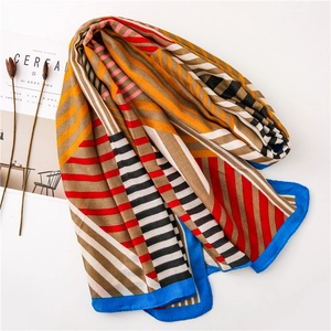 Macro shot of geometric color-block scarf with silk-like texture and blue hem edges