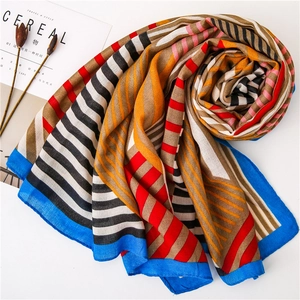 Detailed view of red and blue geometric patchwork scarf with soft cotton-linen texture