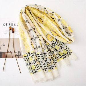 Detail of bohemian cotton linen scarf featuring gold-stamped paisley patterns and tassels