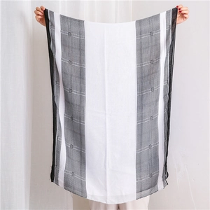 Detail of a thin black and white houndstooth scarf showing semi-transparent texture