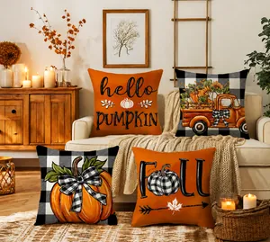 Detail of four fall pumpkin pillow covers with autumn patterns in a cozy home setting