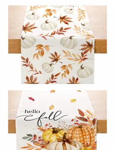 Détail du chemin de table en lin avec citrouilles et feuilles d'érable d'automne