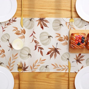 Chemin de table d'automne avec citrouilles blanches et feuilles d'érable sur table