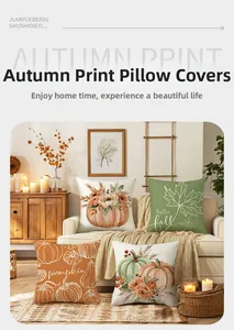Close-up of four autumn pillow covers with pumpkin prints on a warm white sofa