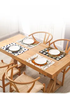 Detail of autumn harvest placemats with pumpkins, plaid patterns and Thankful text