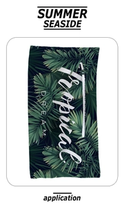 Nahaufnahme des tropischen Palmblattmusters und Tropical DREAM Text auf Strandtuch