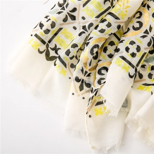 Detail of cotton linen scarf featuring gold foil paisley print and soft tassel edges