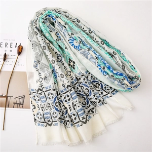 Detail of cotton linen shawl with paisley print and tassels next to decor items