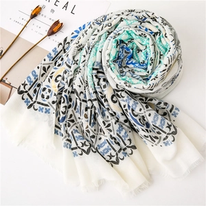 Detail view of cotton linen scarf with blue ethnic patterns and delicate fringe trim