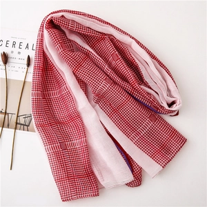 Detail of red and white houndstooth patterned scarf displayed with lifestyle magazine