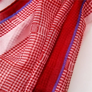 Detail of red and white houndstooth scarf with purple stripes and soft cotton texture